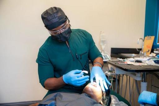 Dr. Abazie fitting custom dentures as part of rest